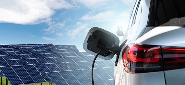 photoshop image of a plugged in electric car in front of solar panels
