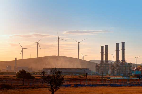 power plant with wind turbines in the background