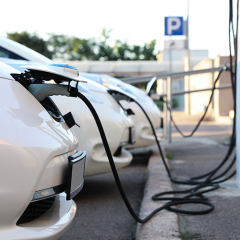 White tesla cars parked at charging station 